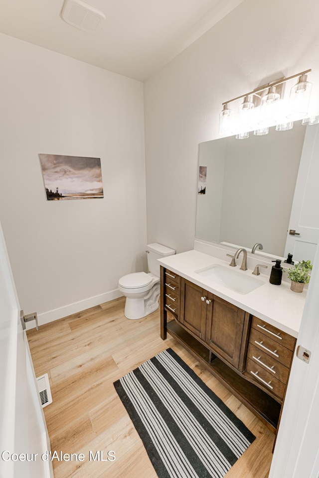204 Silver Saddle Ct, Pinehurst, ID 83850 - half bathroom with vanity, wood finished floors, toilet, and baseboards