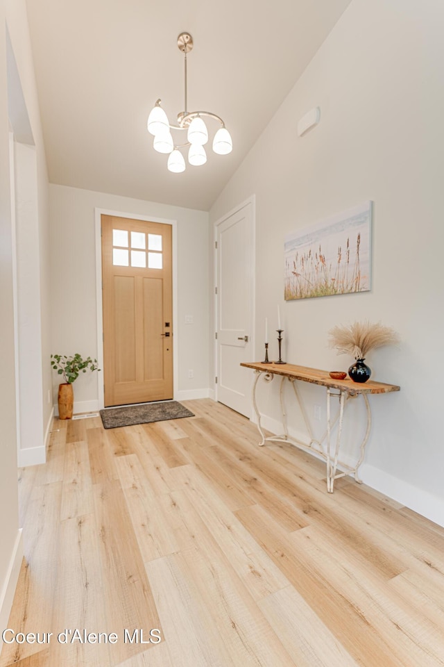 204 Silver Saddle Ct, Pinehurst, ID 83850 - foyer featuring wood finished floors, a chandelier, lofted ceiling, and baseboards