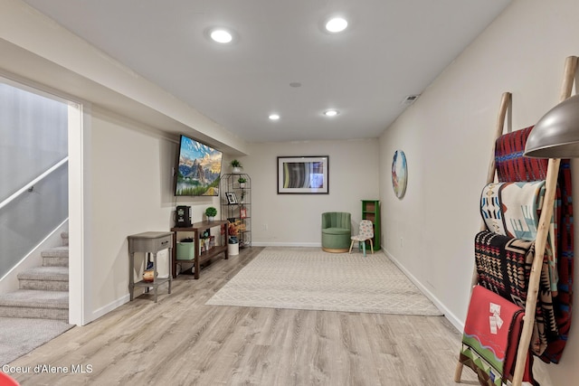 living area with light wood-style floors, baseboards, recessed lighting, and stairs
