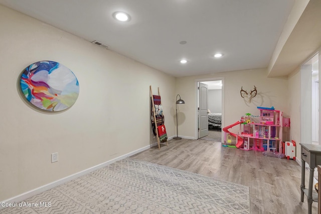 rec room with recessed lighting, baseboards, and wood finished floors
