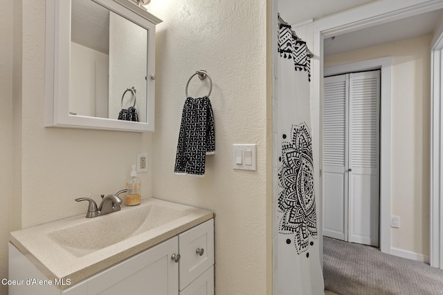 bathroom featuring vanity and a textured wall