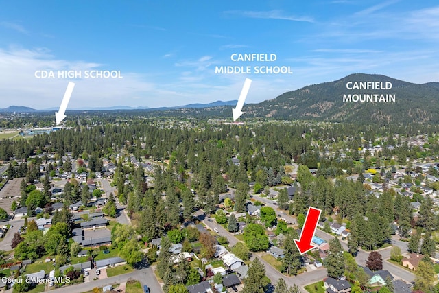 aerial view of property's location featuring a mountainous background and nearby suburban area