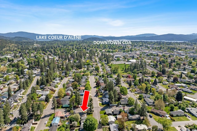 aerial view of property and surrounding area with a mountain backdrop and nearby suburban area