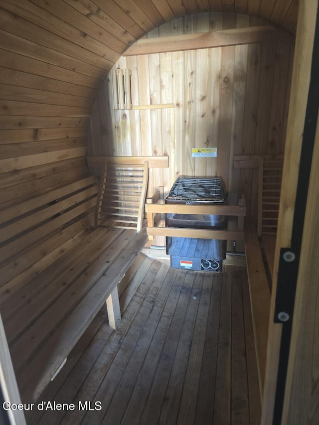 relaxing sauna featuring wood walls and hardwood / wood-style floors
