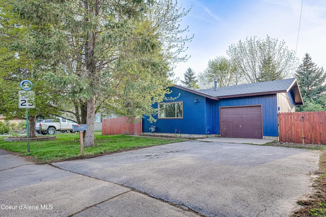 view of front of home with driveway, an attached garage, and a shingled roof