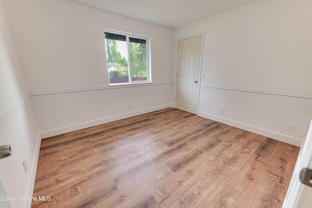 empty room featuring wood finished floors and baseboards