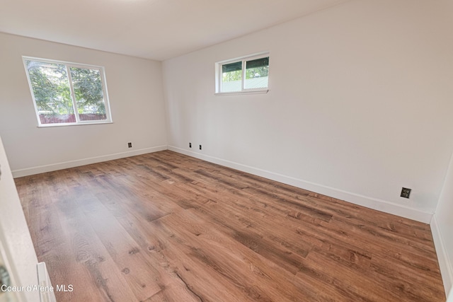 spare room with wood finished floors and baseboards