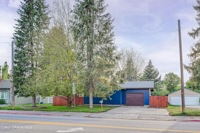 view of front of home with a garage, fence, and concrete driveway