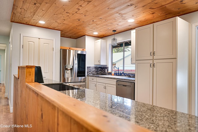 kitchen featuring stainless steel appliances, a sink, recessed lighting, wood ceiling, and tasteful backsplash