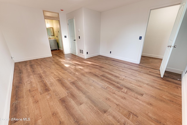 unfurnished bedroom with light wood-style flooring and baseboards