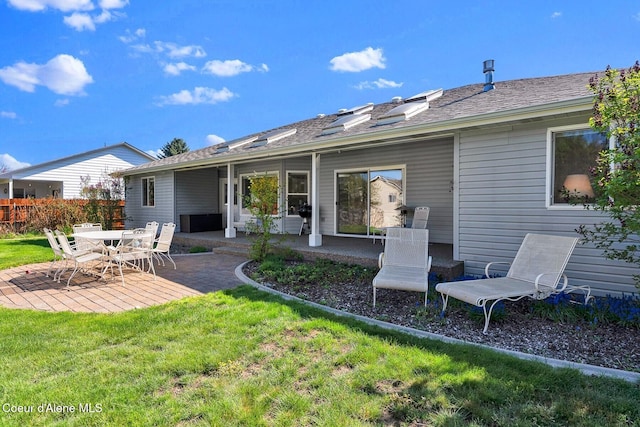 rear view of house with a patio area and a shingled roof