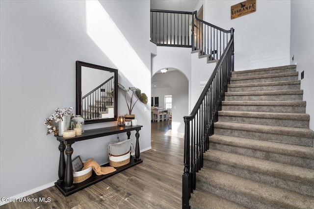 8747 Salmonberry Lp, Hayden, ID 83835 - stairway with arched walkways, wood finished floors, baseboards, and a high ceiling