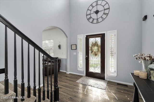 8747 Salmonberry Lp, Hayden, ID 83835 - entrance foyer featuring arched walkways, wood finished floors, healthy amount of natural light, a towering ceiling, and stairway