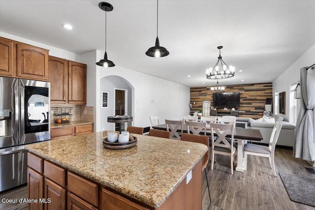 8747 Salmonberry Lp, Hayden, ID 83835 - kitchen with stainless steel fridge, arched walkways, open floor plan, a center island, and decorative backsplash