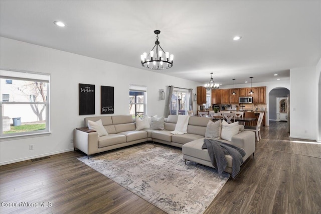 8747 Salmonberry Lp, Hayden, ID 83835 - living area featuring arched walkways, a chandelier, dark wood finished floors, healthy amount of natural light, and recessed lighting