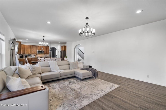 8747 Salmonberry Lp, Hayden, ID 83835 - living room with arched walkways, a chandelier, recessed lighting, dark wood finished floors, and stairway