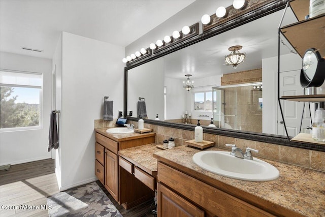 8747 Salmonberry Lp, Hayden, ID 83835 - full bath with a stall shower, a chandelier, double vanity, backsplash, and wood finished floors