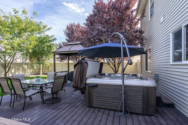 8747 Salmonberry Lp, Hayden, ID 83835 - wooden deck with a hot tub, outdoor dining area, and a fenced backyard