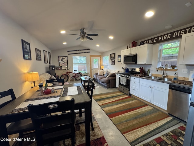 1203 Chestnut St, Sandpoint, ID 83864 - kitchen with appliances with stainless steel finishes, a sink, white cabinets, a ceiling fan, and vaulted ceiling