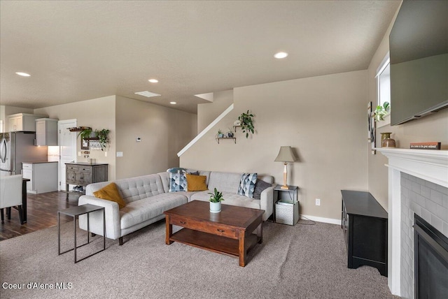 3402 N Croghan Dr, Post Falls, ID 83854 - living area featuring a glass covered fireplace, stairway, recessed lighting, carpet floors, and baseboards
