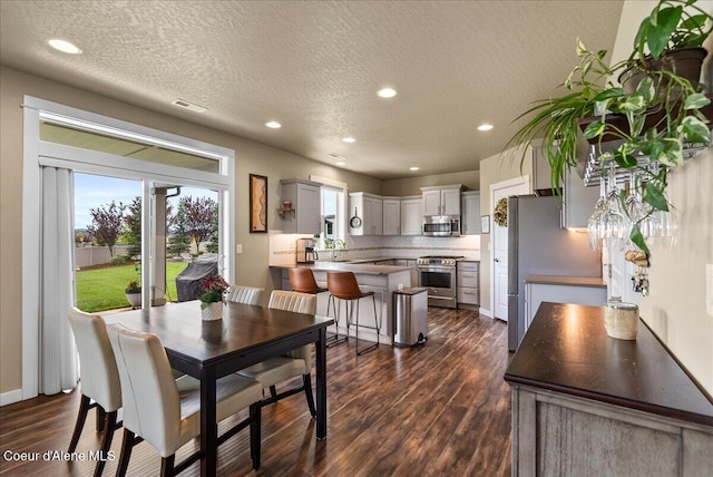 3402 N Croghan Dr, Post Falls, ID 83854 - dining area featuring a textured ceiling, dark wood-type flooring, recessed lighting, and baseboards