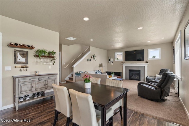 3402 N Croghan Dr, Post Falls, ID 83854 - dining area with dark wood finished floors, a glass covered fireplace, recessed lighting, baseboards, and stairs