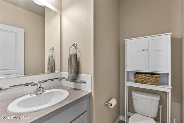 3402 N Croghan Dr, Post Falls, ID 83854 - half bathroom with vanity, toilet, and backsplash