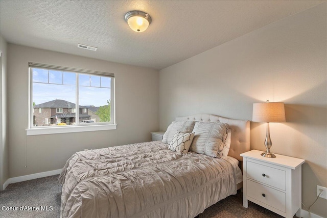 3402 N Croghan Dr, Post Falls, ID 83854 - bedroom with dark carpet, baseboards, and a textured ceiling