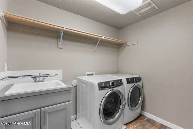 3402 N Croghan Dr, Post Falls, ID 83854 - laundry room featuring cabinet space, washer and dryer, baseboards, and light wood-style floors