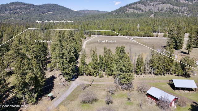 3216 Dufort Rd, Sagle, ID 83860 - aerial overview of property's location featuring a heavily wooded area, a mountainous background, and property parcel outlined