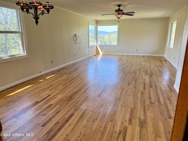 3216 Dufort Rd, Sagle, ID 83860 - spare room featuring wood finished floors, healthy amount of natural light, a chandelier, and a textured ceiling