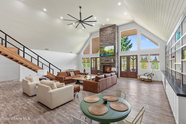 living area featuring wood finished floors, high vaulted ceiling, plenty of natural light, recessed lighting, and a fireplace
