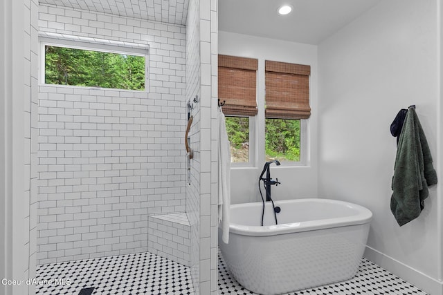 bathroom with a shower stall, a soaking tub, baseboards, and recessed lighting