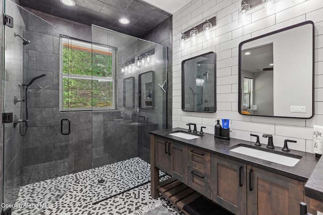 full bath featuring a shower stall, tile walls, plenty of natural light, double vanity, and backsplash