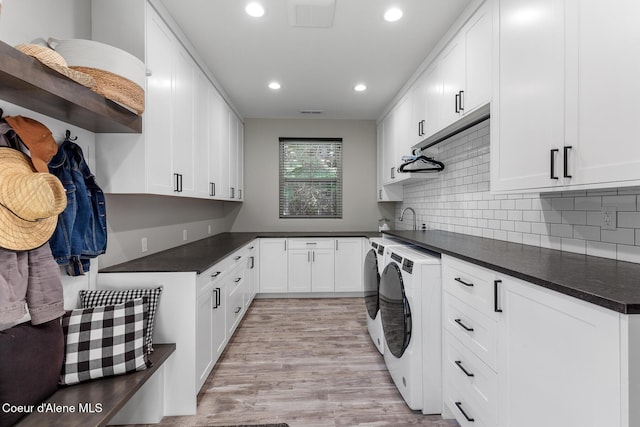 laundry area featuring washer and dryer, cabinet space, recessed lighting, and light wood finished floors