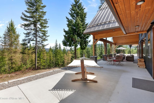 view of patio with outdoor dining space and a wooded view