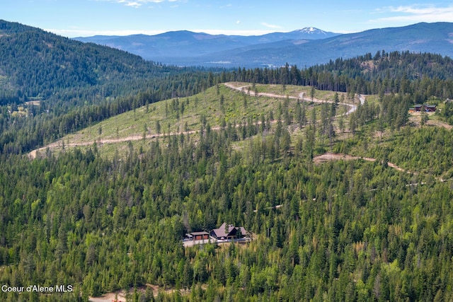 aerial view of property's location with a heavily wooded area and mountains