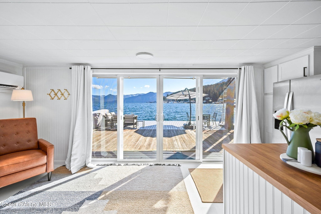 FN N Harborview Marina Unit 9, Bayview, ID 83803 - entryway with a water and mountain view, an AC wall unit, and carpet floors