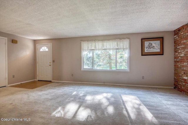 entryway with a textured ceiling, carpet, and baseboards