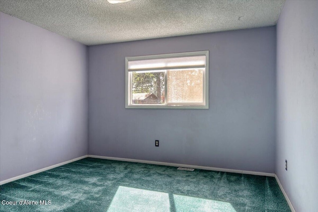 spare room with carpet floors, baseboards, and a textured ceiling