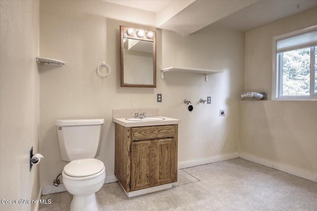 bathroom featuring toilet, baseboards, and vanity