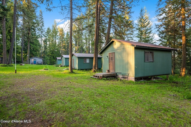 8072 W Radmer Rd, Rathdrum, ID 83858 - rear view of house with a yard, an outdoor structure, metal roof, and a shed