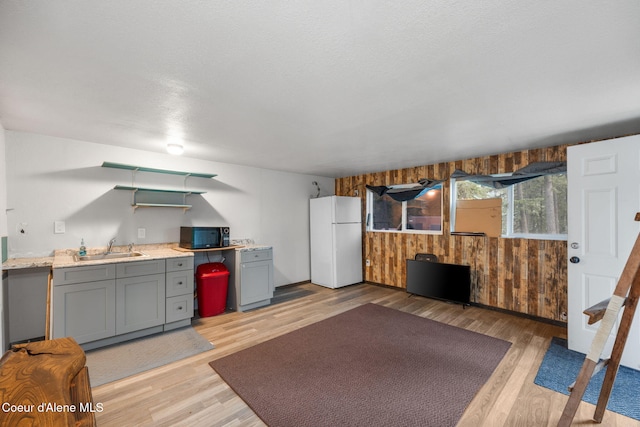 8072 W Radmer Rd, Rathdrum, ID 83858 - kitchen featuring freestanding refrigerator, a sink, gray cabinetry, black microwave, and light wood-style flooring