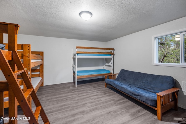 8072 W Radmer Rd, Rathdrum, ID 83858 - bedroom with a textured ceiling, wood finished floors, and baseboards
