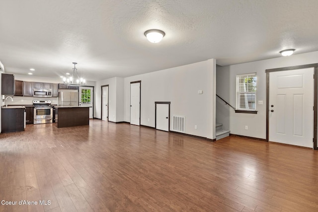 1201 E Locust Ave, Coeur Dalene, ID 83814 - unfurnished living room with a sink, a chandelier, stairs, baseboards, and dark wood-style floors