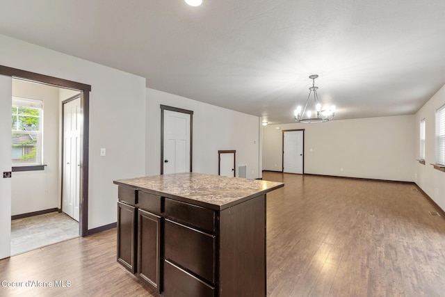 1201 E Locust Ave, Coeur Dalene, ID 83814 - kitchen with dark brown cabinets, plenty of natural light, light wood finished floors, and a chandelier