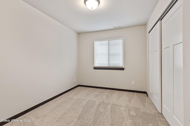 1201 E Locust Ave, Coeur Dalene, ID 83814 - unfurnished bedroom featuring light colored carpet, baseboards, and a closet