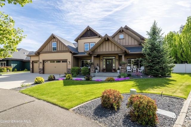 craftsman-style house with board and batten siding, stone siding, a porch, and driveway