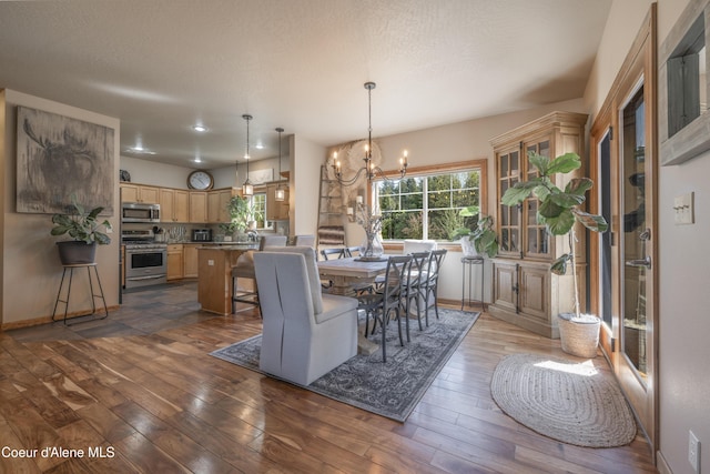 dining space featuring a chandelier, dark wood-style flooring, and baseboards