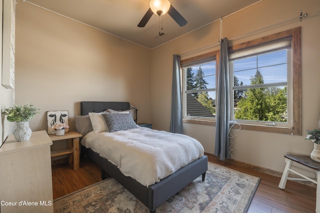 bedroom with wood finished floors, baseboards, and ceiling fan